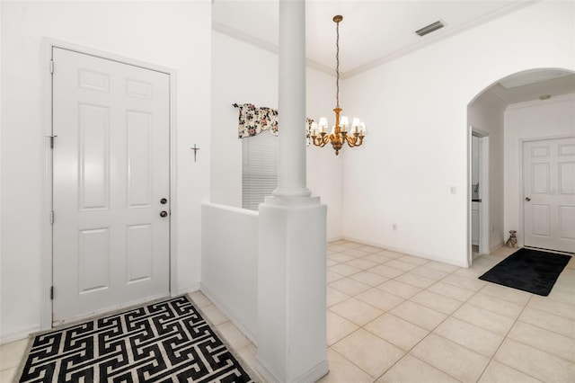 9101 Yarberry St, Sarasota, FL 34240 - entryway with arched walkways, ornamental molding, a chandelier, light tile patterned floors, and baseboards