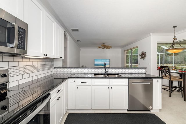 9101 Yarberry St, Sarasota, FL 34240 - kitchen featuring stainless steel appliances, a sink, a ceiling fan, backsplash, and dark stone countertops