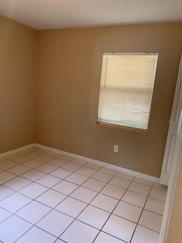 unfurnished room with baseboards and light tile patterned floors