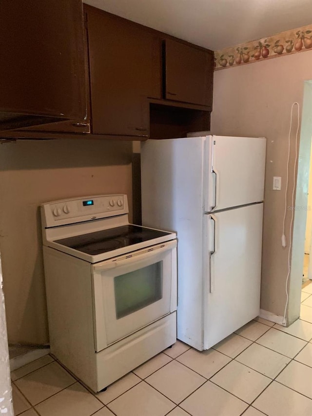 kitchen with dark brown cabinets, white appliances, and light tile patterned floors