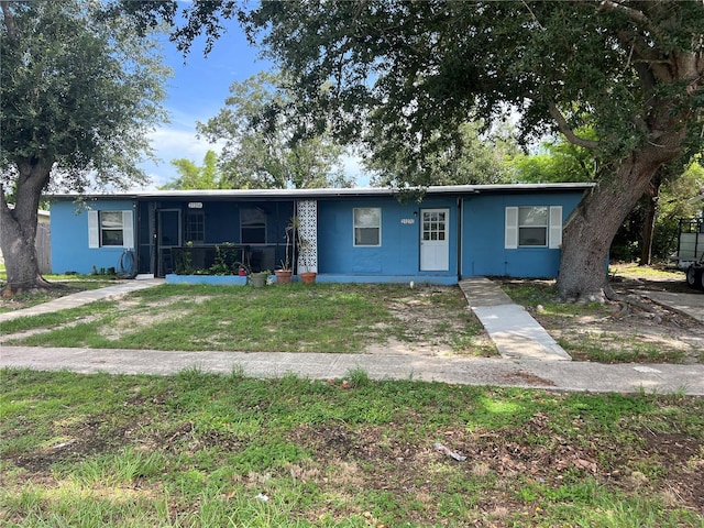 21266 Coulton Ave, Port Charlotte, FL 33952 - view of front of home with a front lawn and a sunroom