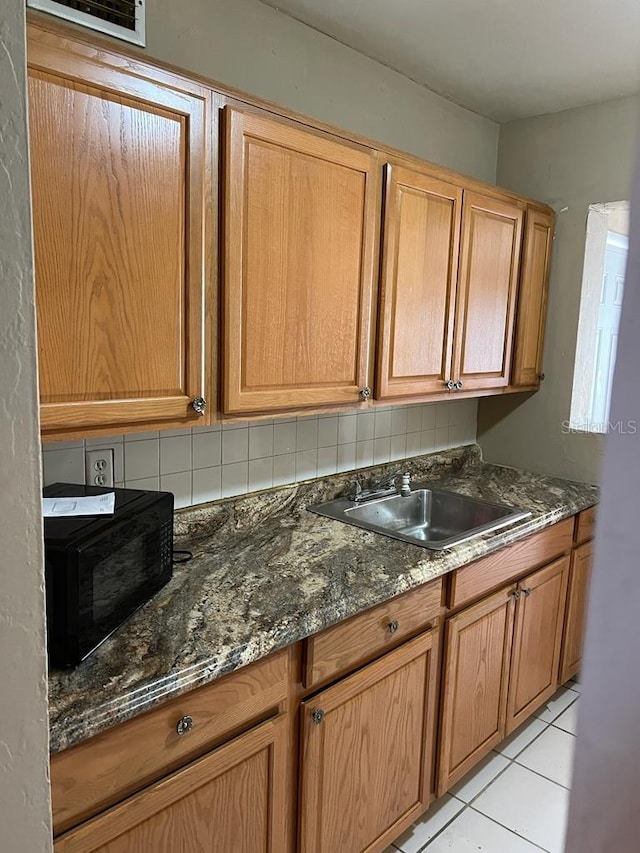 21291 Coulton Ave, Port Charlotte, FL 33952 - kitchen with black microwave, dark stone countertops, light tile patterned floors, and decorative backsplash