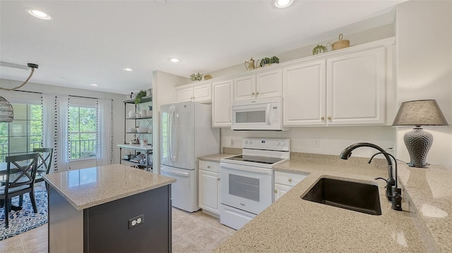 9008 White Sage Loop Unit 3605, Lakewood Ranch, FL 34202 - kitchen with a sink, white appliances, white cabinetry, light stone countertops, and a kitchen island