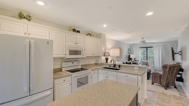 9008 White Sage Loop Unit 3605, Lakewood Ranch, FL 34202 - kitchen with white appliances, a sink, white cabinetry, open floor plan, and a peninsula
