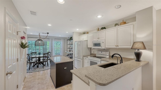 9008 White Sage Loop Unit 3605, Lakewood Ranch, FL 34202 - kitchen with a sink, white cabinets, visible vents, white appliances, and a kitchen island