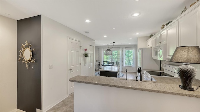 9008 White Sage Loop Unit 3605, Lakewood Ranch, FL 34202 - kitchen featuring white cabinetry, a peninsula, light stone countertops, and white appliances