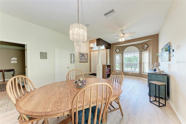 dining space with light wood finished floors, ornate columns, visible vents, baseboards, and ceiling fan with notable chandelier