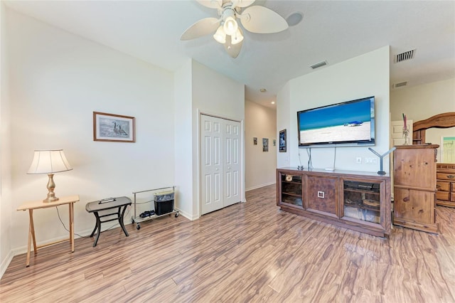 living area with wood finished floors, visible vents, baseboards, and ceiling fan