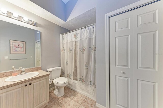 full bathroom with tile patterned floors, toilet, vanity, shower / tub combo, and a textured ceiling