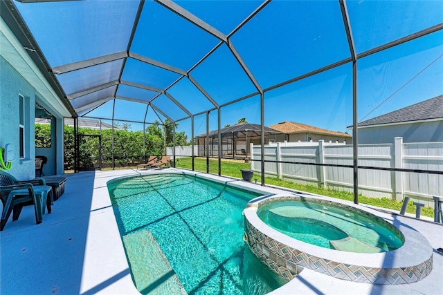 view of swimming pool with fence, a patio area, glass enclosure, and a pool with connected hot tub