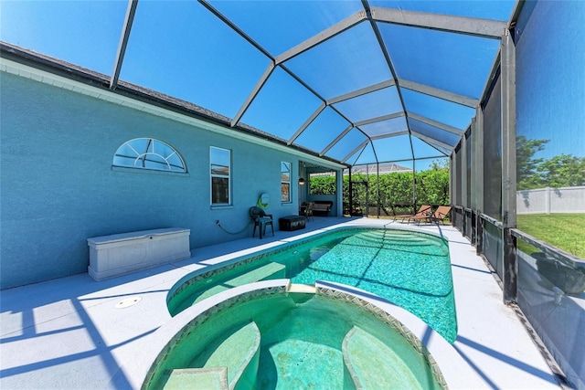 view of swimming pool featuring a patio area, glass enclosure, and a pool with connected hot tub