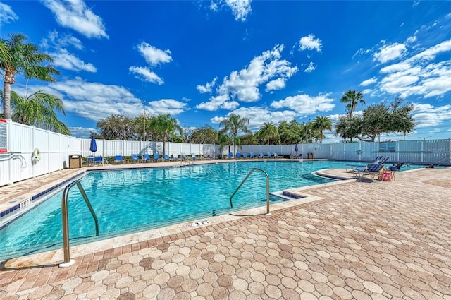 community pool with fence and a patio area