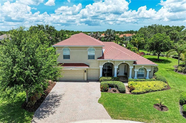 12838 Daisy Pl, Bradenton, FL 34212 - mediterranean / spanish home featuring a garage, driveway, a front lawn, stucco siding, and a tiled roof