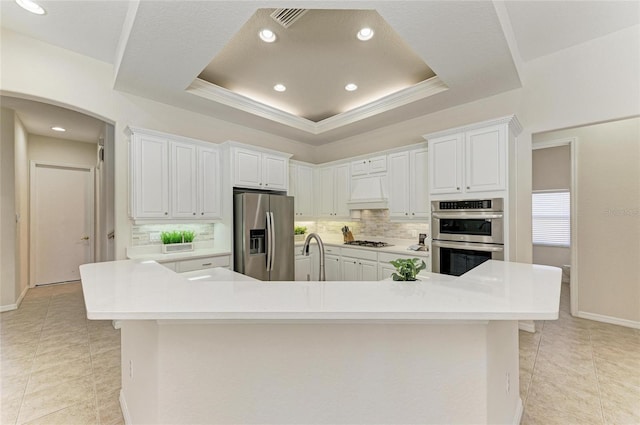 12838 Daisy Pl, Bradenton, FL 34212 - kitchen featuring appliances with stainless steel finishes, tasteful backsplash, light tile patterned flooring, light countertops, and white cabinets