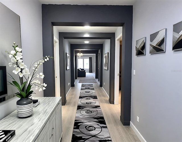 4970 Oyster Pearl St, Lakewood Ranch, FL 34211 - hall with baseboards, a notable chandelier, and light wood finished floors