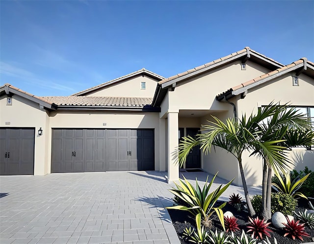 4970 Oyster Pearl St, Lakewood Ranch, FL 34211 - view of front of home featuring a tile roof, a garage, stucco siding, and decorative driveway