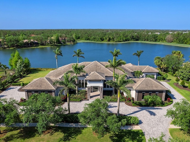 birds eye view of property featuring a forest view and a water view