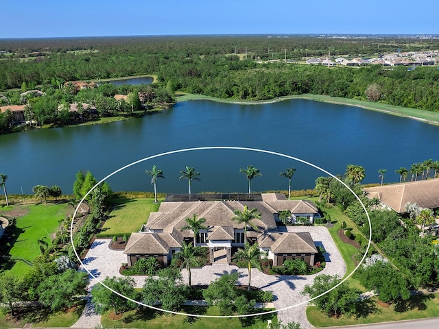 birds eye view of property with a wooded view and a water view