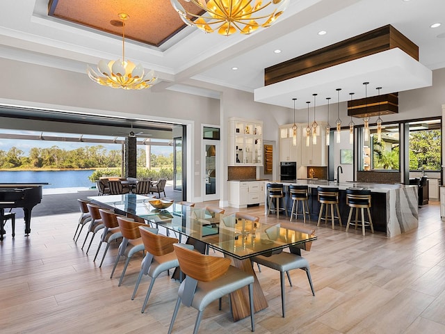 dining room with recessed lighting, a high ceiling, a chandelier, and light wood-style floors