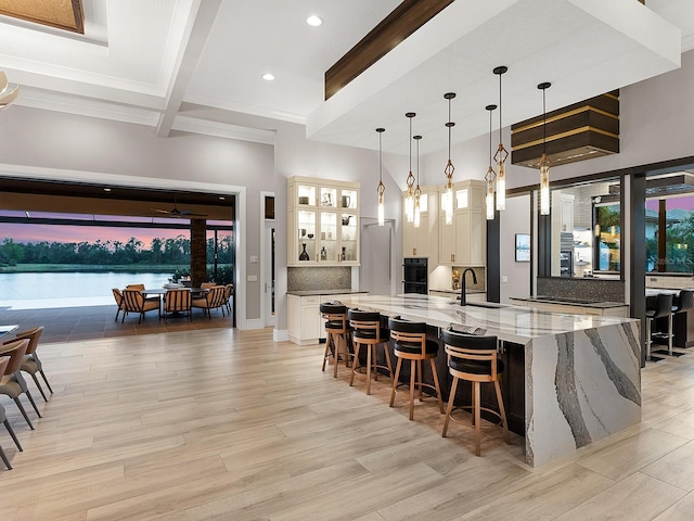 bar with beam ceiling, recessed lighting, light wood finished floors, and a sink