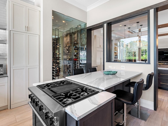 wine room with crown molding, baseboards, and light wood-style floors
