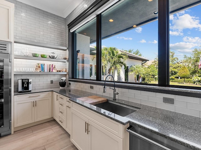 kitchen featuring a wealth of natural light, backsplash, dishwasher, and a sink
