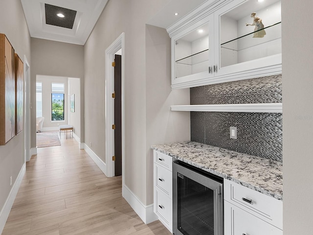 bar with baseboards, light wood finished floors, decorative backsplash, and wine cooler