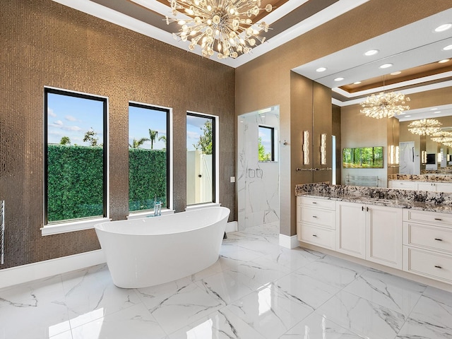 full bath featuring a wealth of natural light, a freestanding bath, and an inviting chandelier