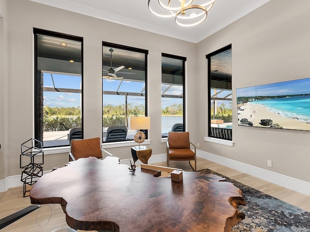sitting room featuring baseboards, ceiling fan with notable chandelier, light wood-style floors, and crown molding