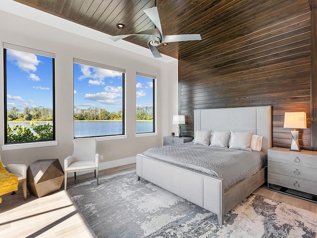 bedroom featuring wood walls, multiple windows, and wooden ceiling