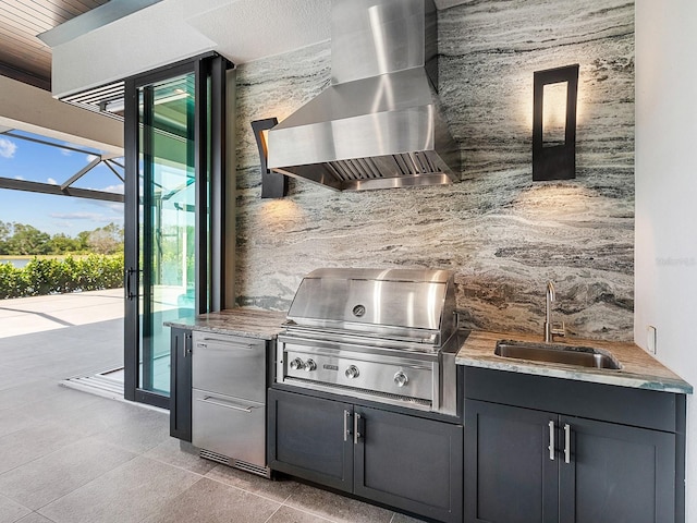 exterior space with fridge, light tile patterned floors, light countertops, a sink, and wall chimney exhaust hood