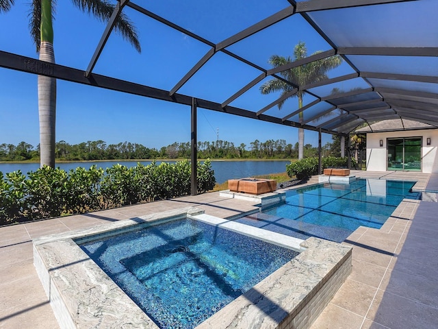 outdoor pool featuring a patio, glass enclosure, a water view, and an in ground hot tub