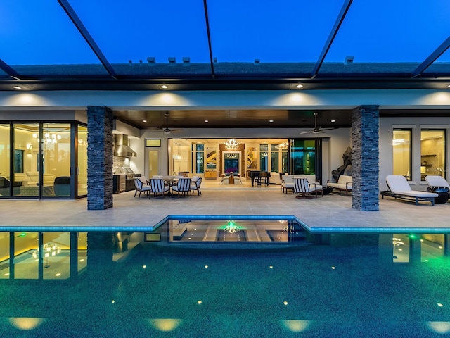 back of house at twilight with a patio, a ceiling fan, and a pool with connected hot tub