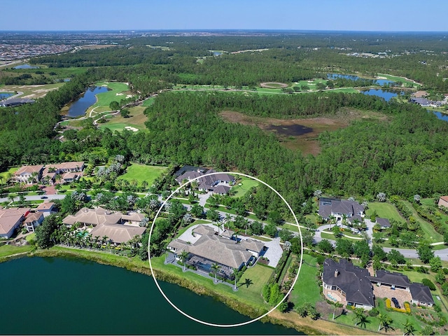 drone / aerial view featuring a wooded view, a water view, and a residential view