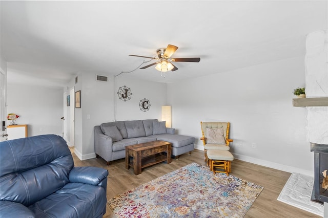 14519 Catalina Cir, Seminole, FL 33776 - living room featuring a fireplace with flush hearth, baseboards, visible vents, wood finished floors, and ceiling fan