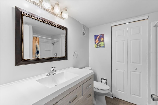 14519 Catalina Cir, Seminole, FL 33776 - full bathroom featuring wood finished floors, vanity, a shower with curtain, toilet, and visible vents