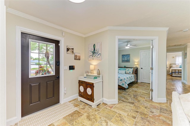 entryway with ceiling fan, stone tile floors, baseboards, and ornamental molding