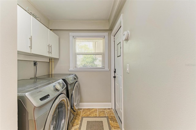 laundry room with washing machine and dryer, baseboards, stone finish flooring, cabinet space, and ornamental molding