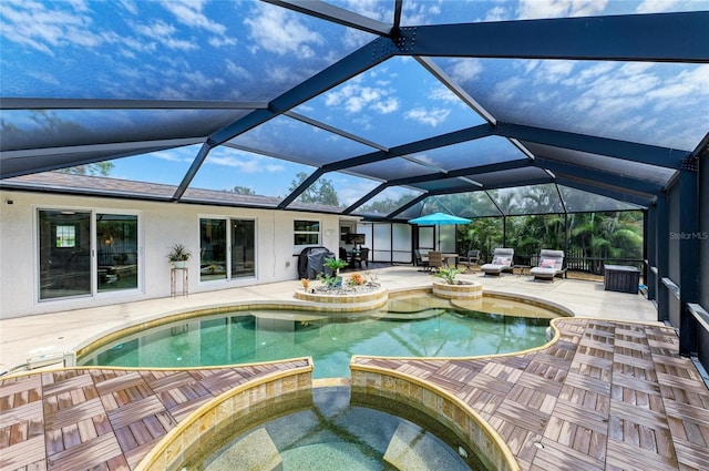 view of swimming pool with a patio area, glass enclosure, and a pool with connected hot tub
