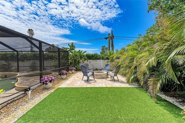 view of yard with a fenced in pool, fence, glass enclosure, a patio area, and a fire pit