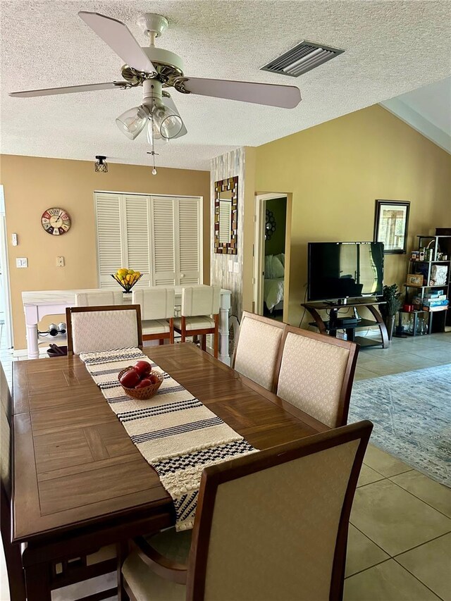 tiled dining area with a textured ceiling, visible vents, and ceiling fan