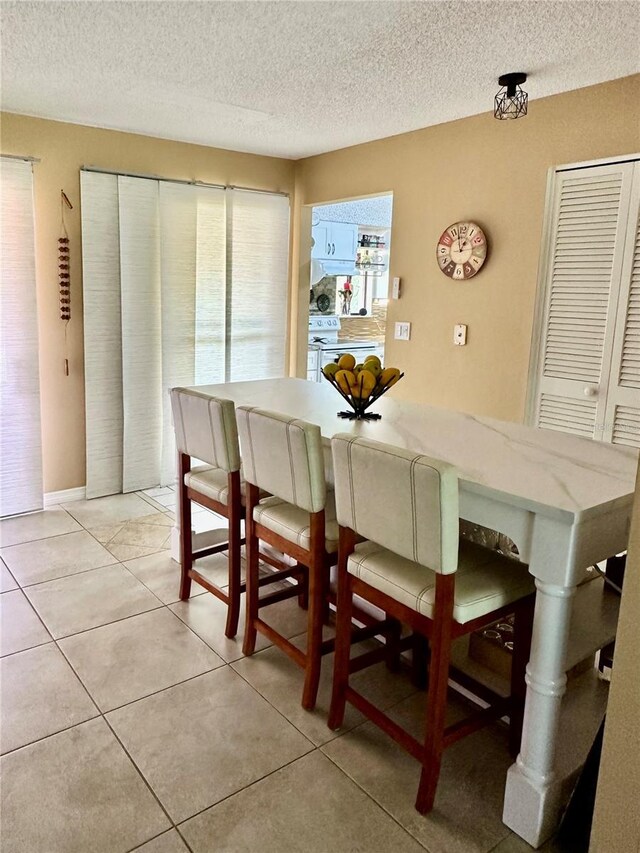 dining room featuring a textured ceiling and light tile patterned floors