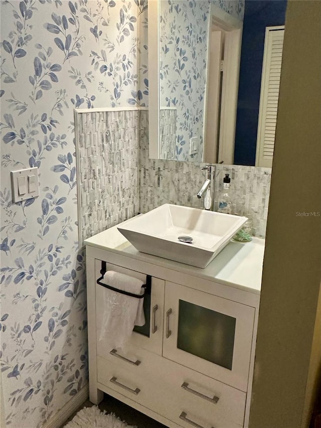 bathroom with wallpapered walls and vanity