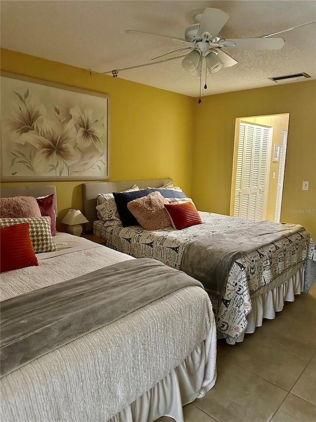 bedroom featuring a ceiling fan, visible vents, and tile patterned flooring