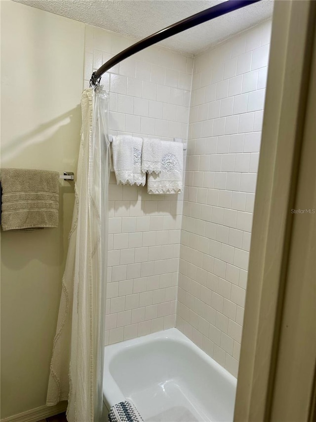 bathroom featuring a textured ceiling and shower / tub combo