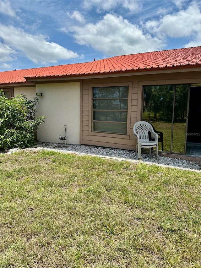 rear view of property with a yard and stucco siding