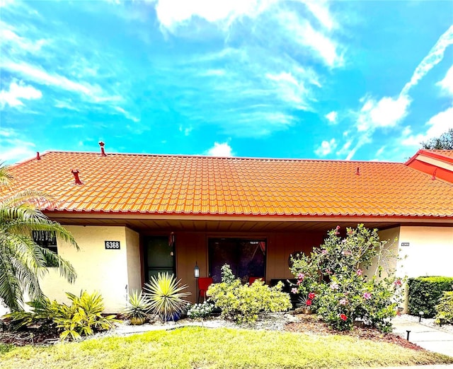 view of front facade featuring a tiled roof and stucco siding