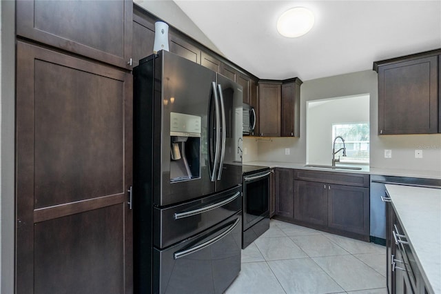 kitchen with a sink, range with electric stovetop, light countertops, stainless steel microwave, and refrigerator with ice dispenser