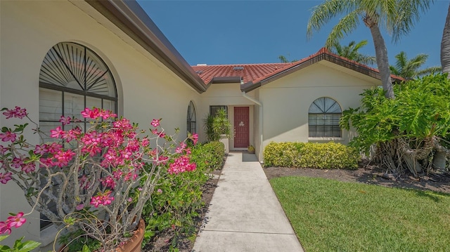4691 Las Brisas Ln, Sarasota, FL 34238 - entrance to property featuring stucco siding, a yard, and a tiled roof
