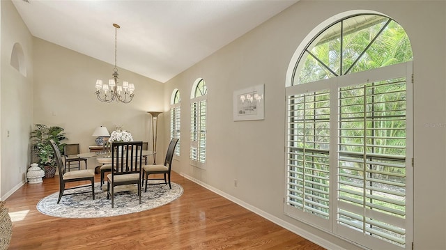 4691 Las Brisas Ln, Sarasota, FL 34238 - dining space featuring baseboards, a chandelier, wood finished floors, and high vaulted ceiling